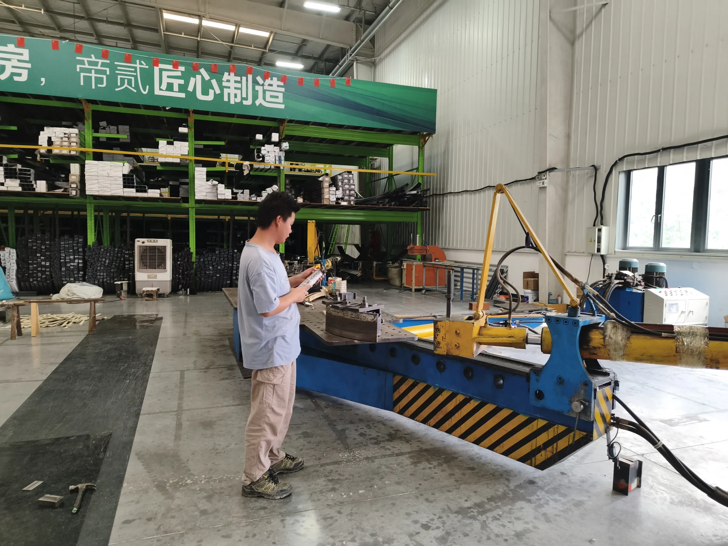 Factory operator checking aluminum components at machining equipment