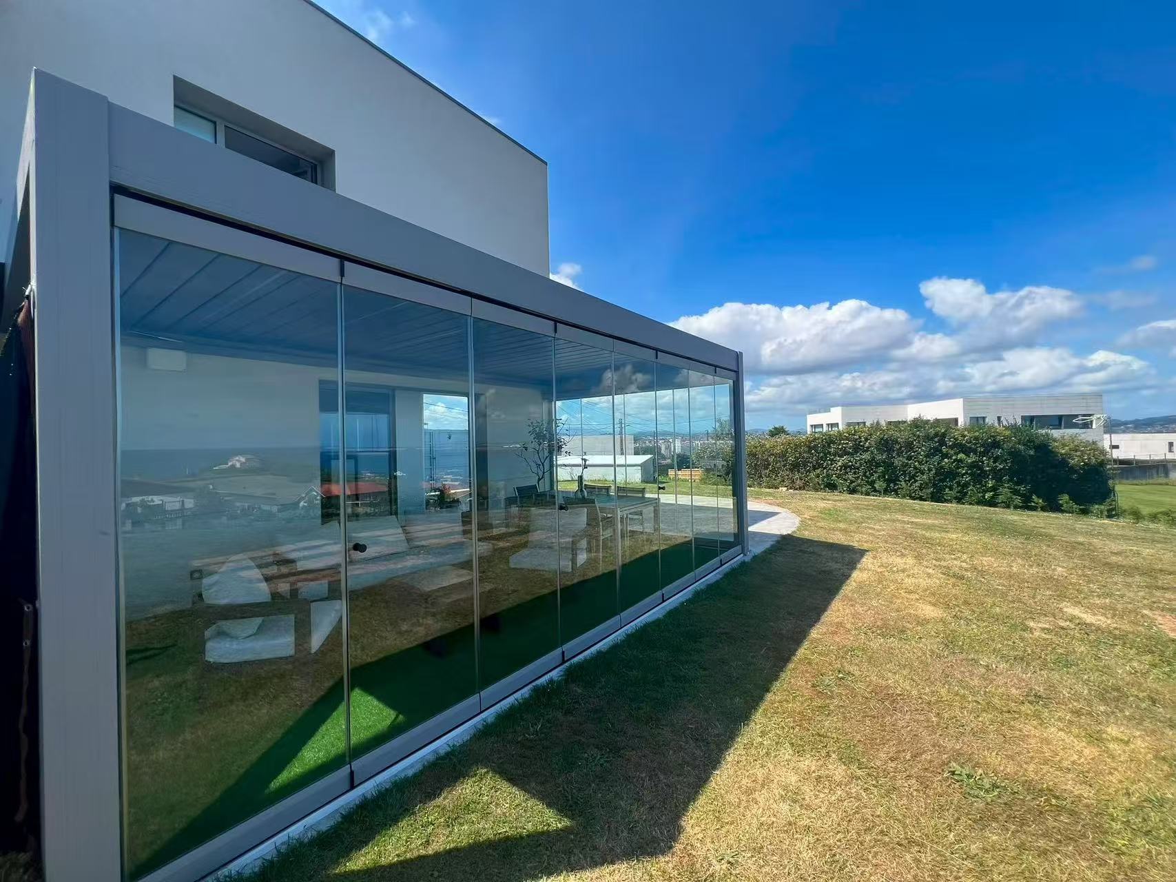 JIAKE aluminum pergola project with a motorized roof and frameless glass enclosure