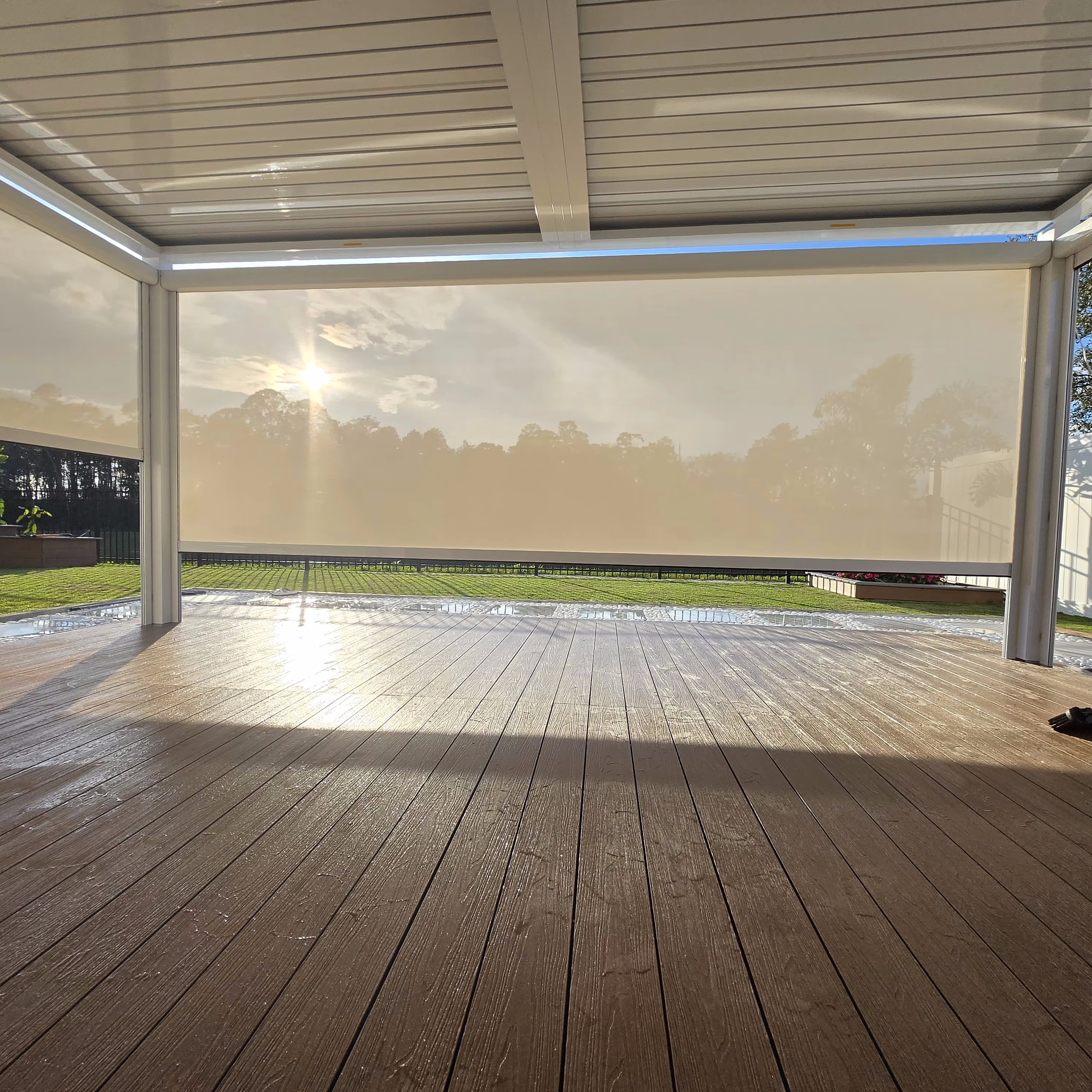 Closed aluminum pergola louvers with a lowered side roller blind