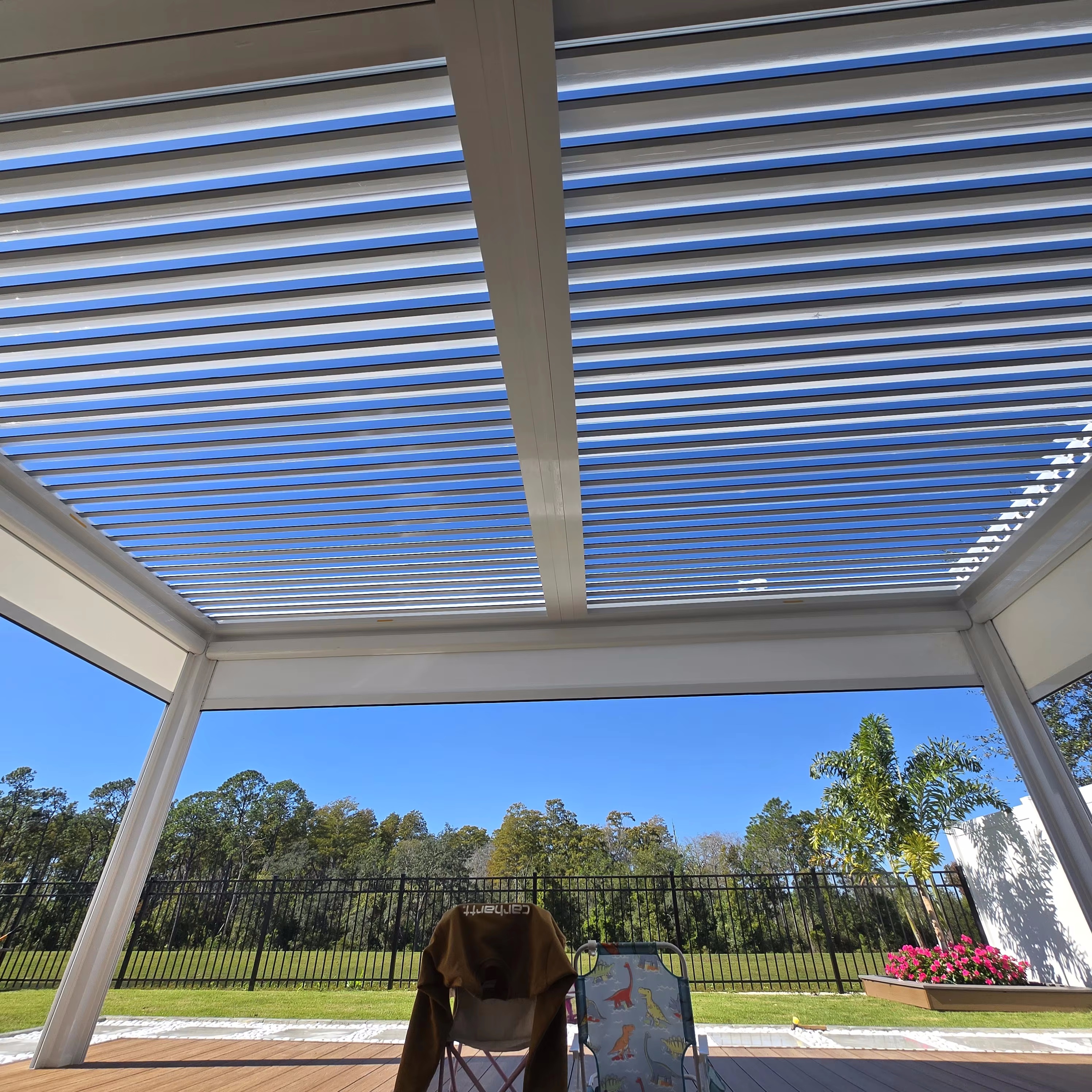 Open aluminum pergola louvers admitting daylight and airflow