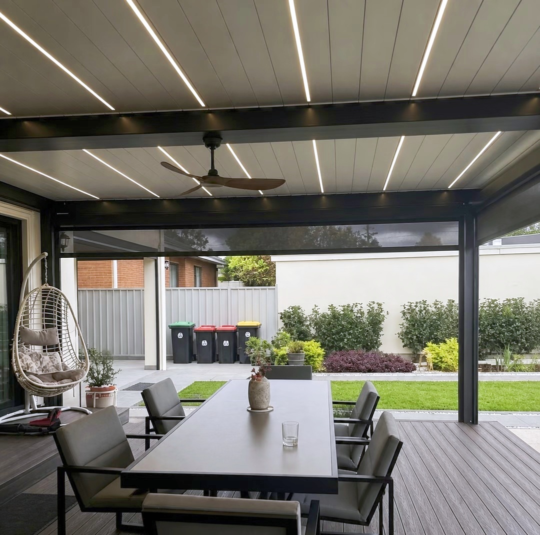 Closed aluminum pergola louvers with integrated lighting above an outdoor dining area