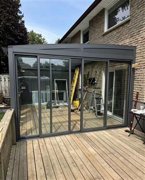 Compact aluminum sunroom installed beside a Canadian home