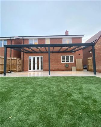 Completed fixed glass-roof pergola over a UK garden patio