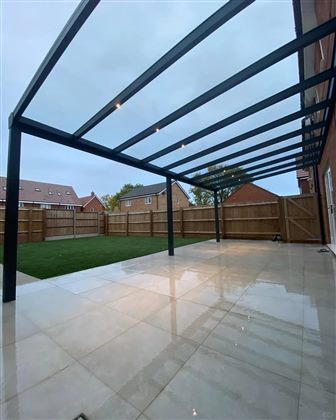 Integrated lighting beneath a fixed glass-roof aluminum pergola