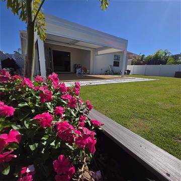 White aluminum pergola beside the customer’s garden and deck