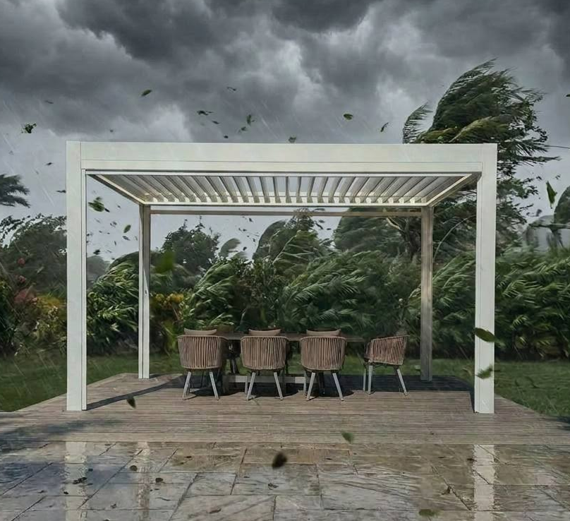 White aluminum louvered pergola exposed to strong wind and rain